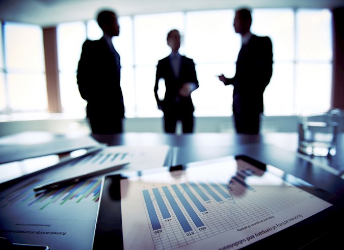 Financial planners conferring in the background near their business table.